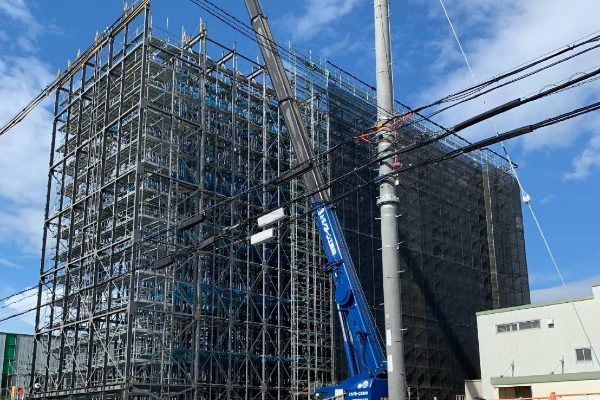 大型ビルを覆う大規模な仮設足場とクレーン