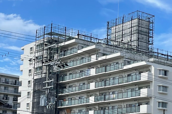 マンション屋上部の足場と青空